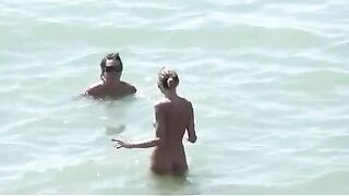 Watch these smooth nudists play at a public beach