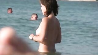 Nudist girls have fun with each other at the beach