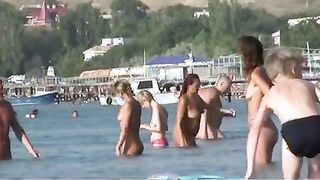 Nudist girls have fun with each other at the beach
