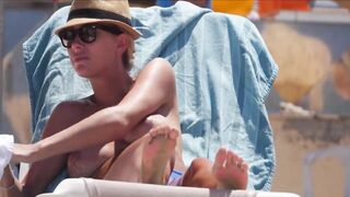 Frisky blonde babe expose her perky awesome tits on topless beach