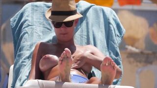 Frisky blonde babe expose her perky awesome tits on topless beach