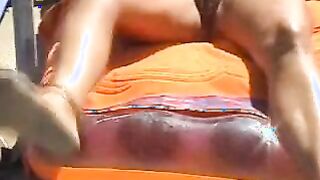 Beach spread on a nude beach of a Milf